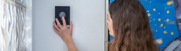 Vrouw zet thermostaat lager