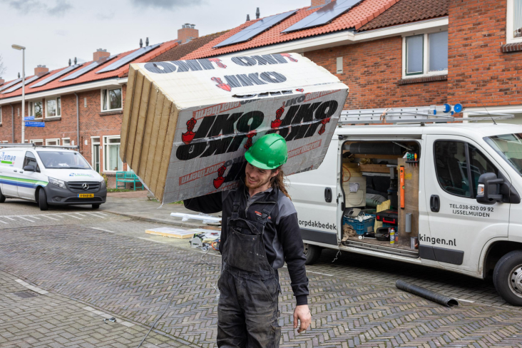Bouwvakker sjouwt met isolatiemateriaal