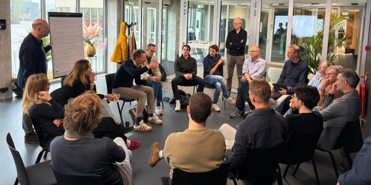 Foto van een open space waarbij een groep mensen met elkaar in gesprek is