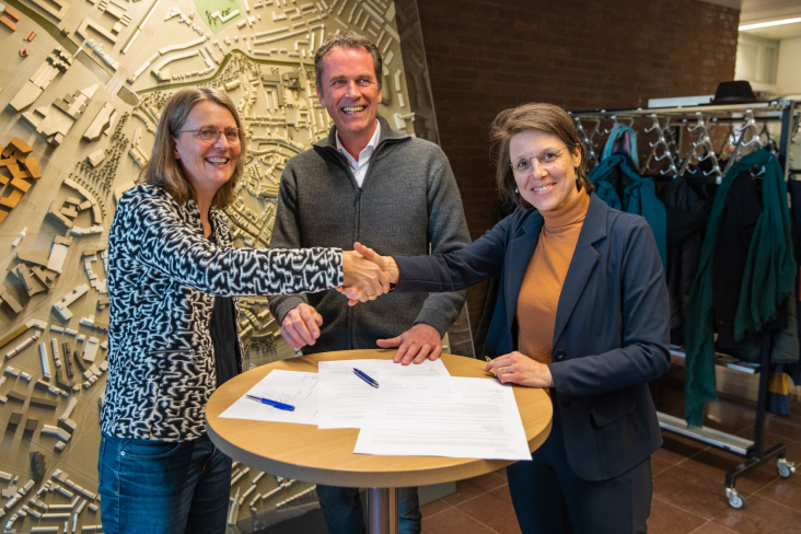 Gemeente en collectief schudden elkaar de hand na het tekenen van een overeenkomst
