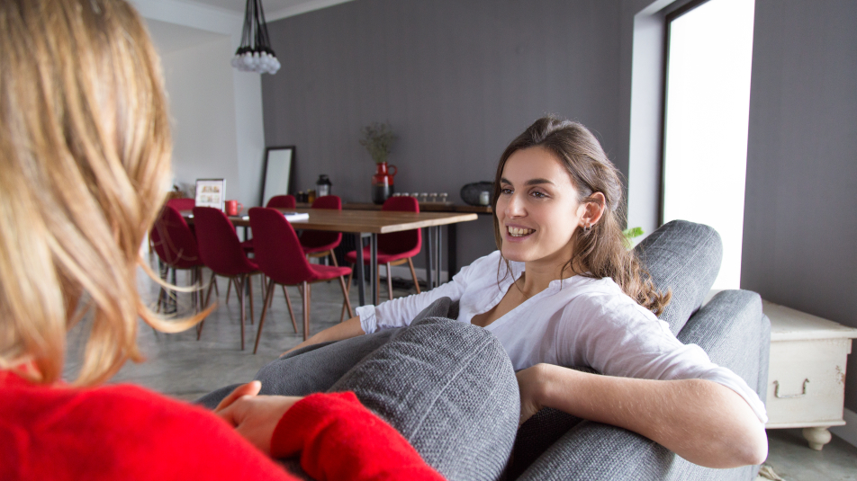 Twee mensen in gesprek in een huiskamer